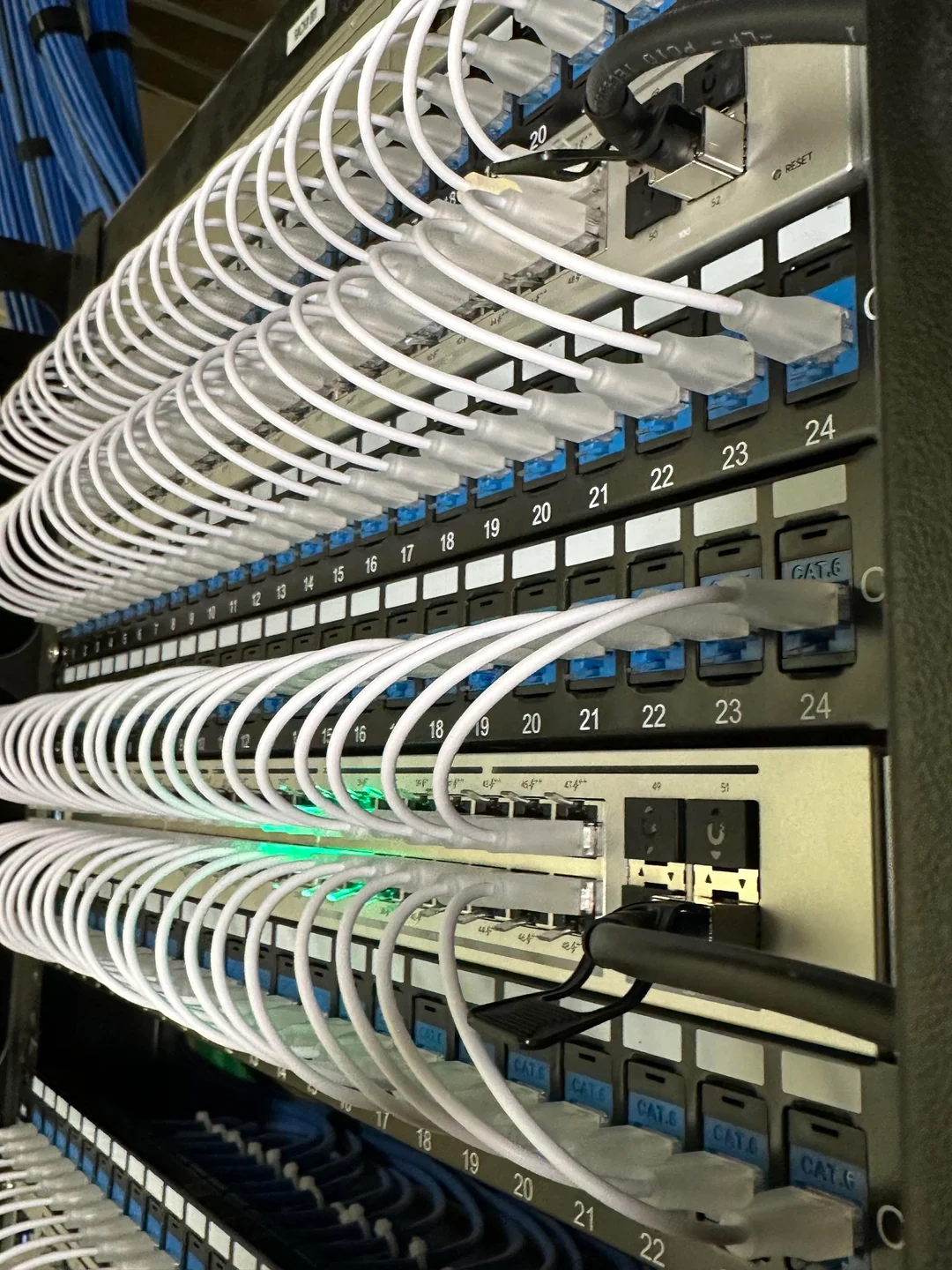 Switch UniFi y cableado de red durante trabajo técnico de Trinity Systems